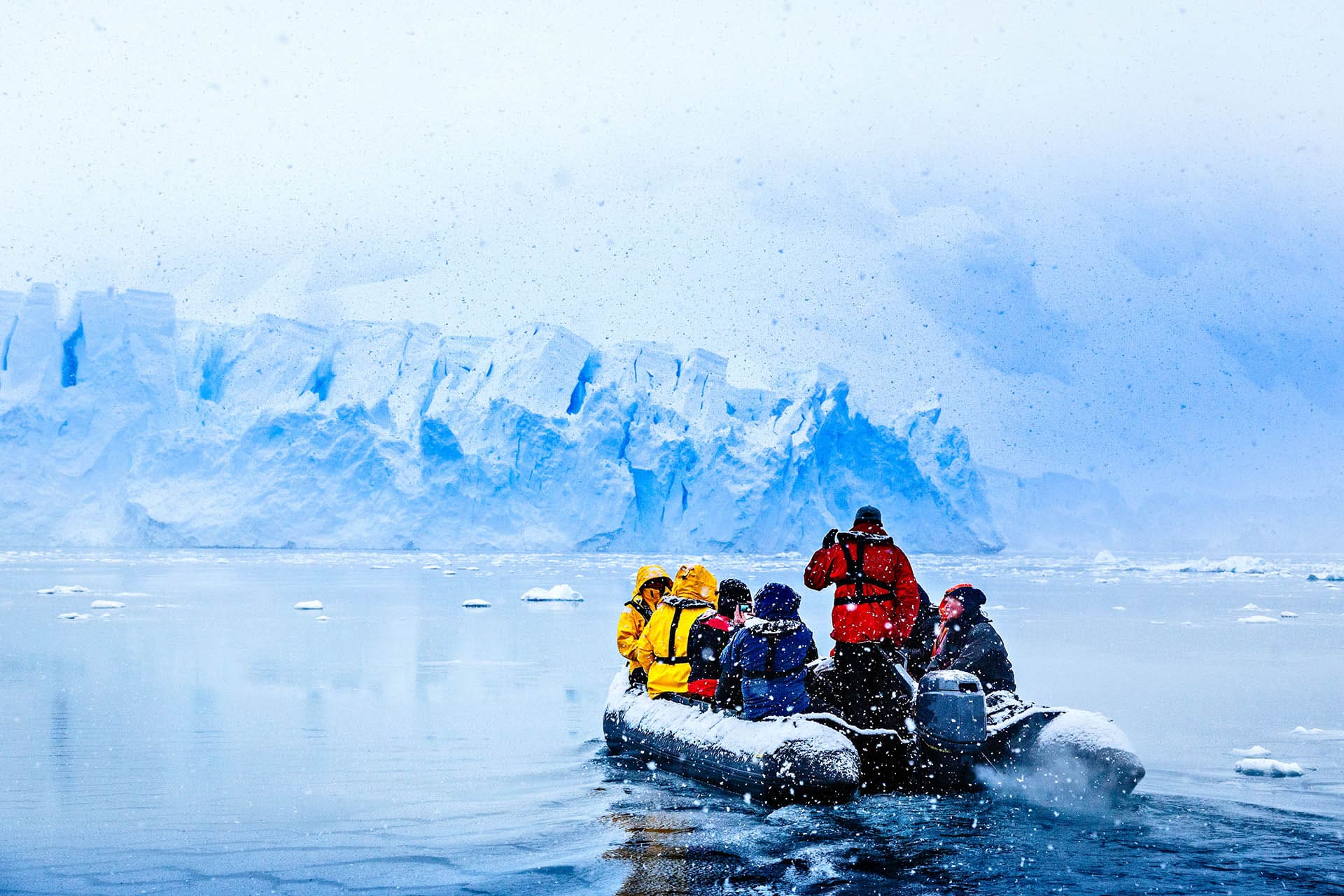 Snowfall over the boat with frozen tourists driving towards the